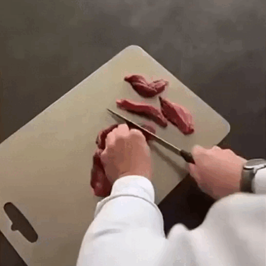 Titanium Cutting Board being washed under running water—easy-to-clean stainless design saves kitchen space